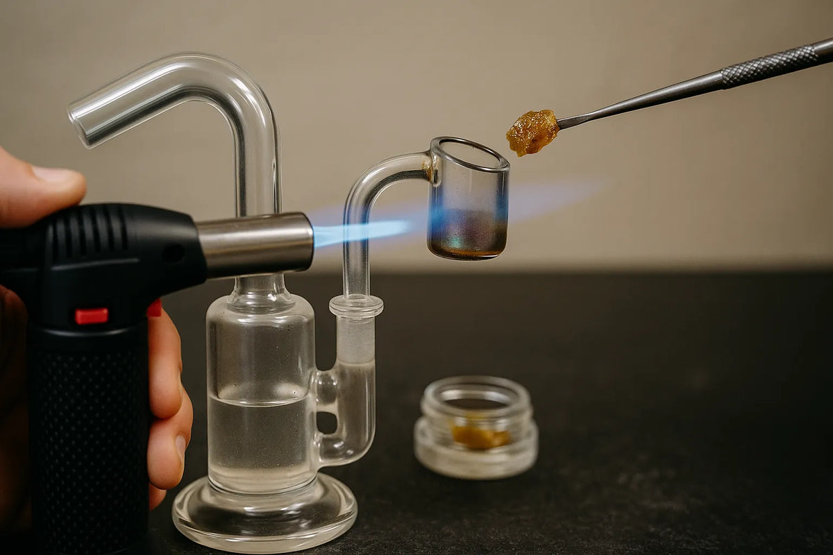 Човек използва dab rig, за да вдиша канабис концентрат, отблизо в спокойна домашна обстановка.